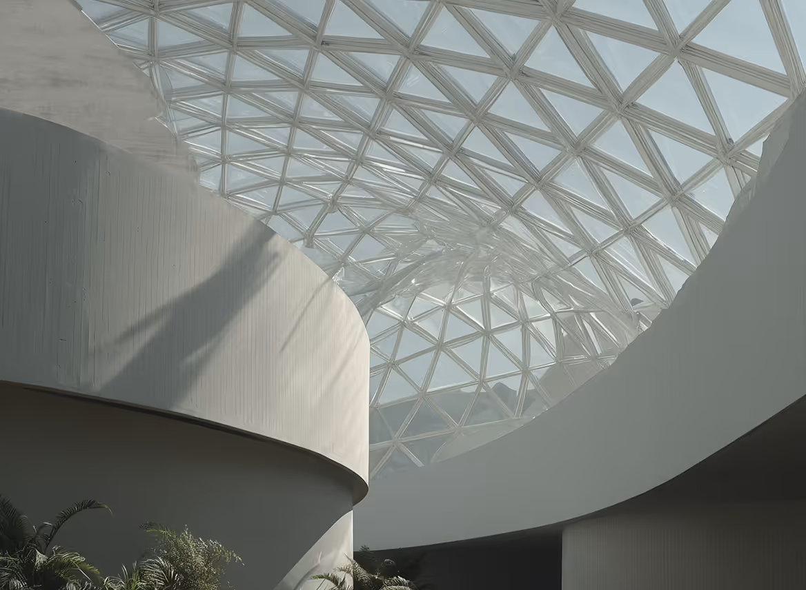 Interior view of a modern building with curved white walls and a geometric glass roof letting in natural light.