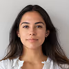 Portrait of a woman with long dark hair wearing a white top and minimalist earrings.